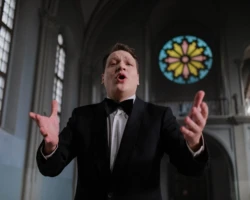 Photo credit: Cottonbro Studio Opera singer performing passionately inside a church with stained glass window in the background.